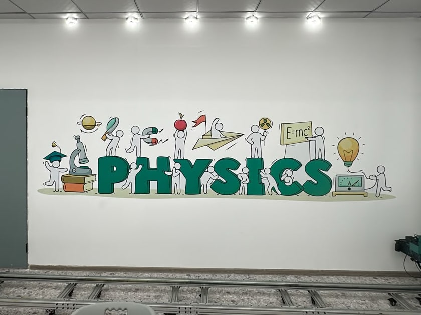 Стена кабинета физики со словом PHYSICS и нарисованными маленькими учёными